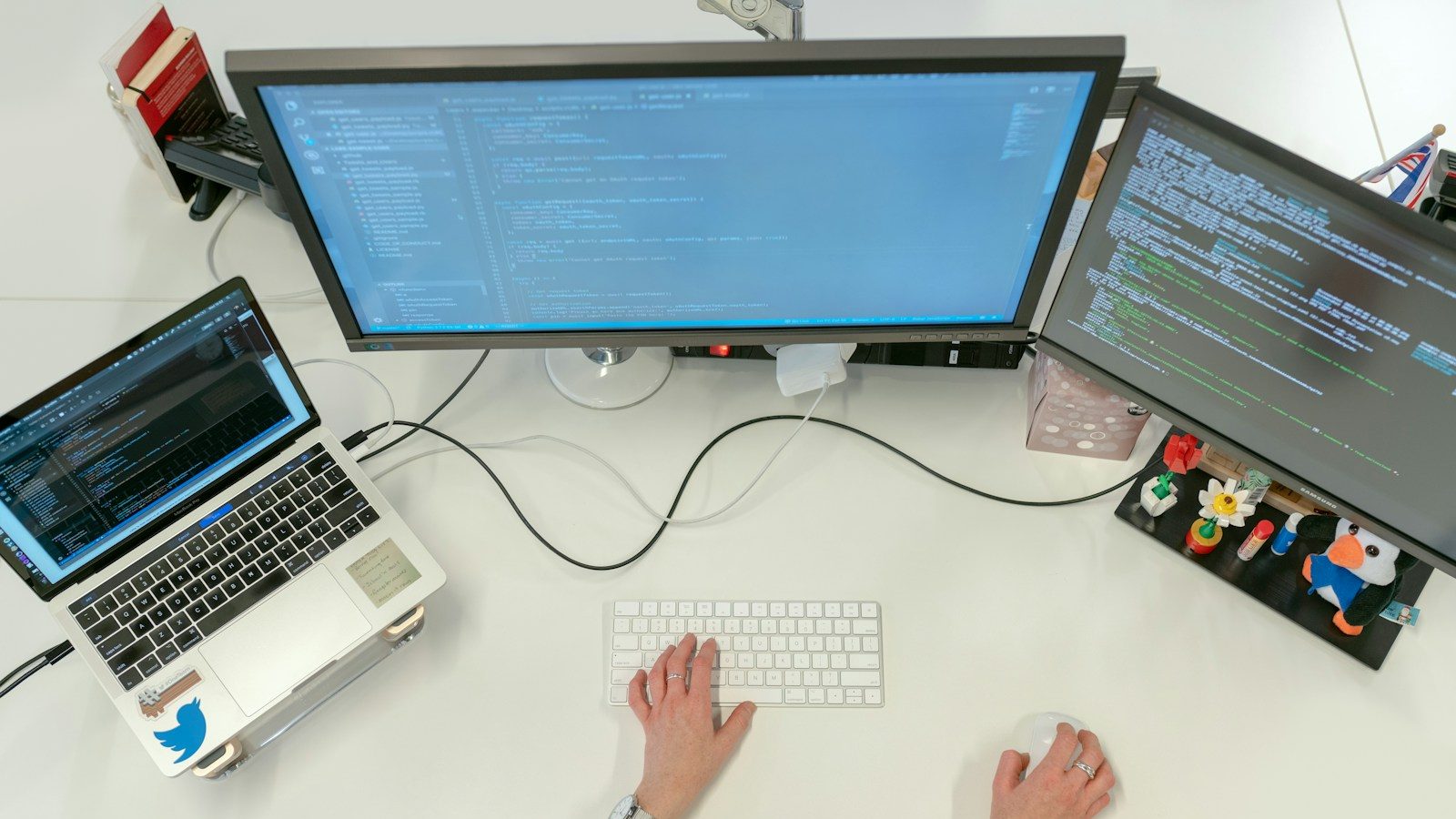 person using macbook pro on white table